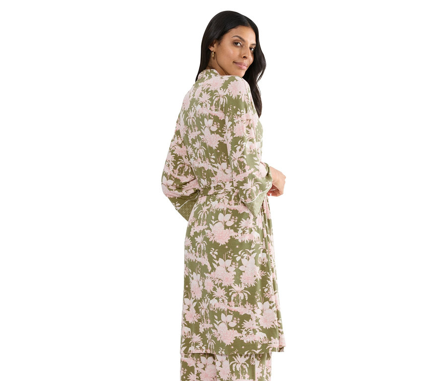 Kobieta ma na sobie zielony szlafrok w różowe kwiaty z paskiem.