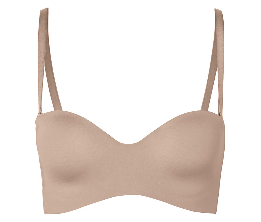 Beżowy biustonosz bez ramiączek z ramiączkami leży na białym tle.