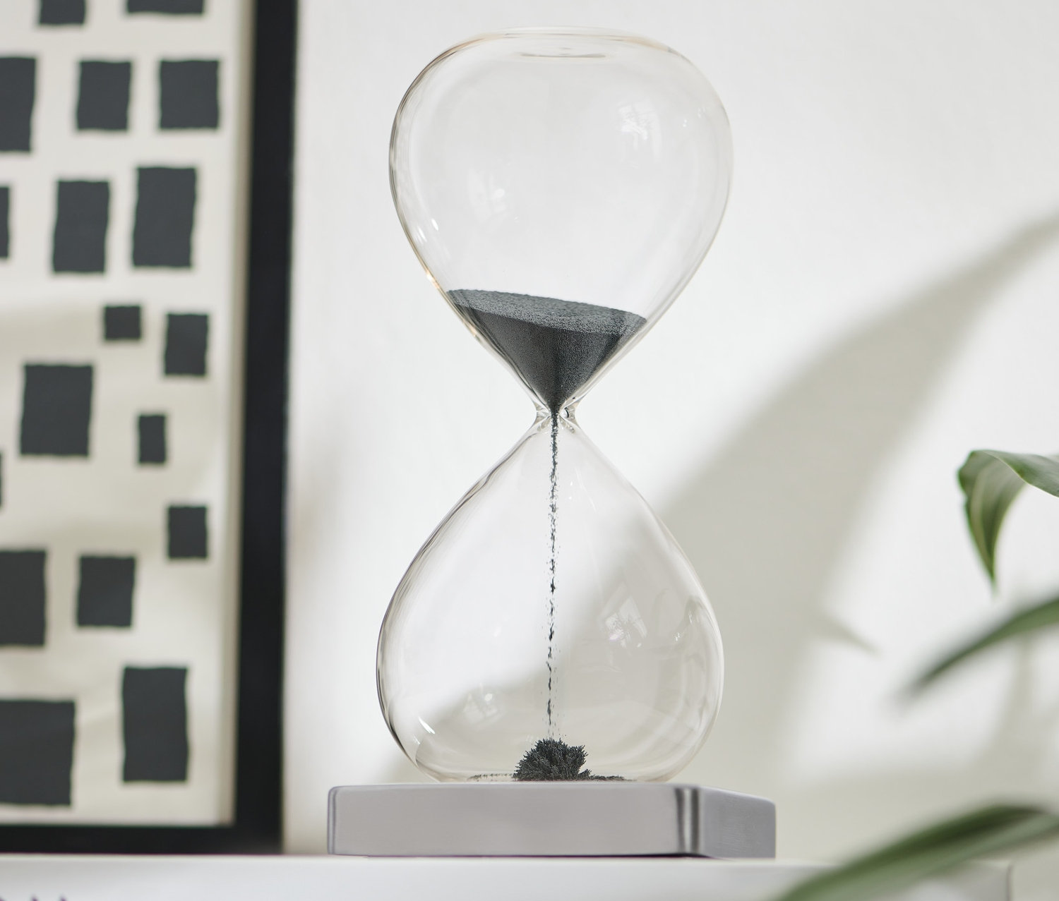 Czarna klepsydra magnetyczna na białej książce.