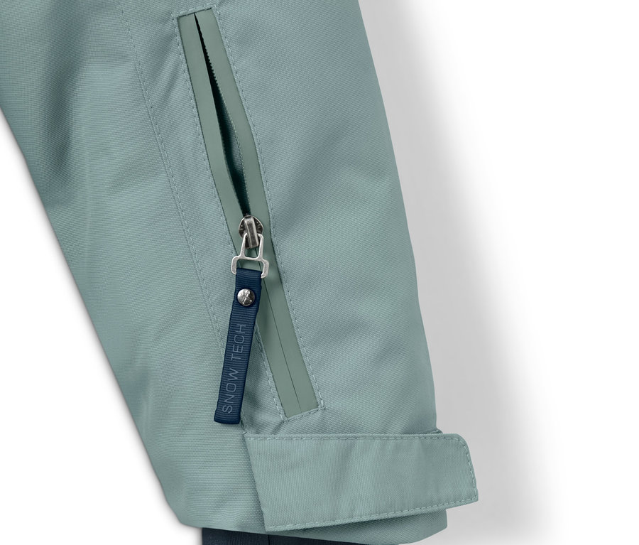 Szczegół dziecięcej kurtki turystyczno-snowboardowej z zamkiem błyskawicznym.