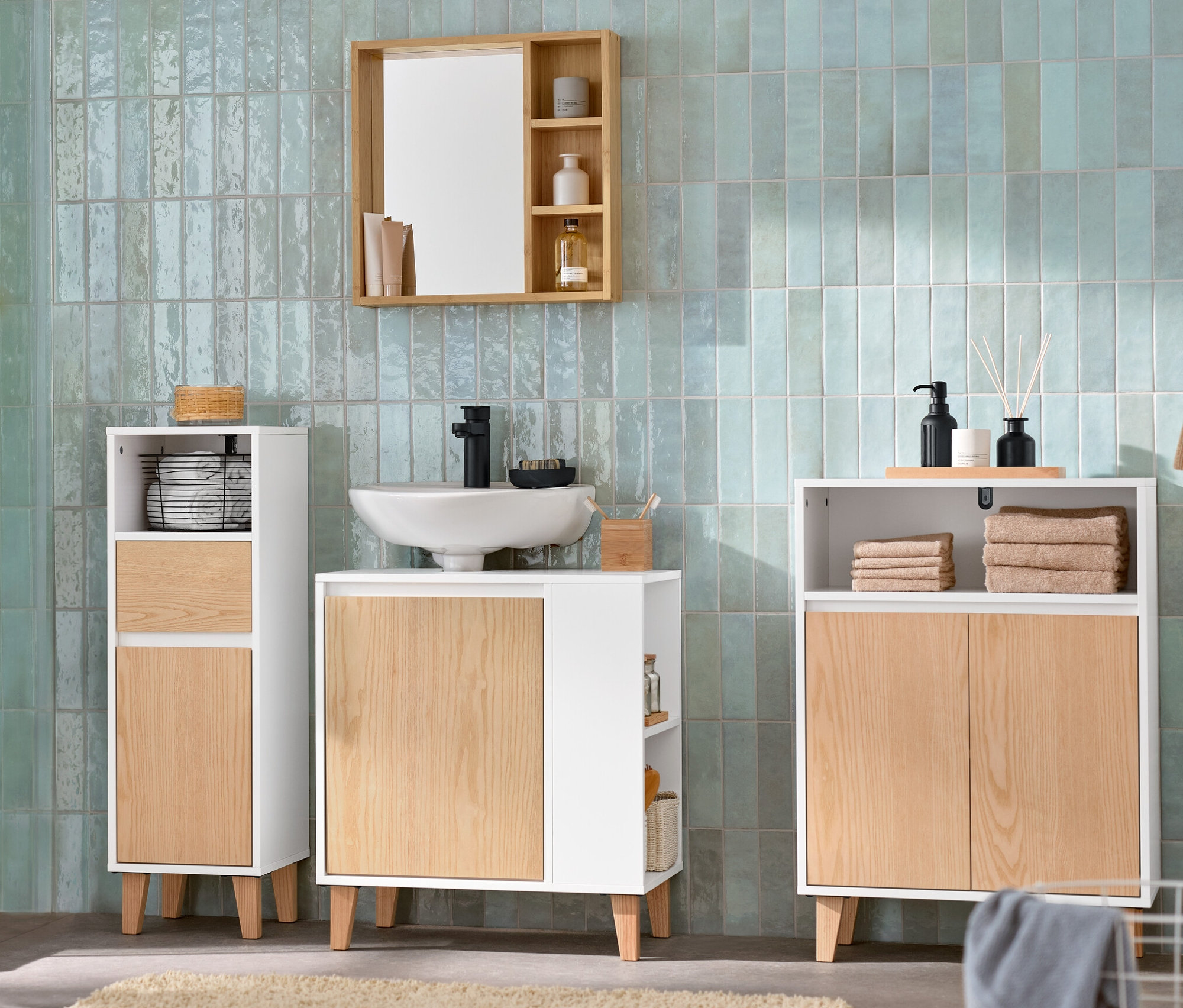 Łazienka z szafką pod umywalkę z boczną przegródką, lustrem z półkami, szafką łazienkową i wąską szafką łazienkową.