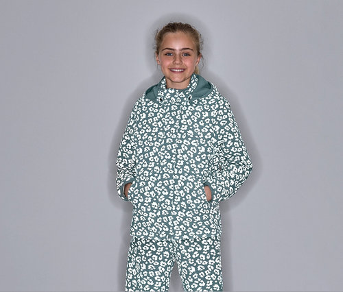 Dziewczyna pozuje w termicznej kurtce przeciwdeszczowej z elementami odblaskowymi i wzorem w cętki.