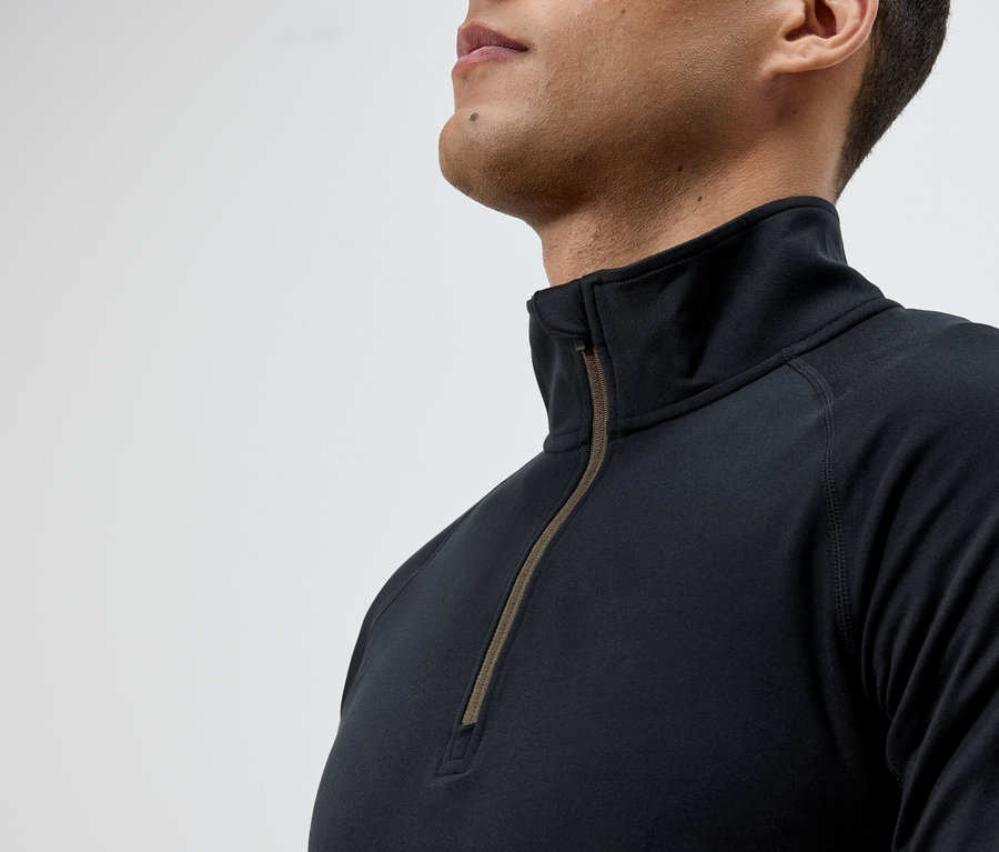 Mężczyzna ma na sobie czarną koszulkę z długim rękawem i zamkiem błyskawicznym.
