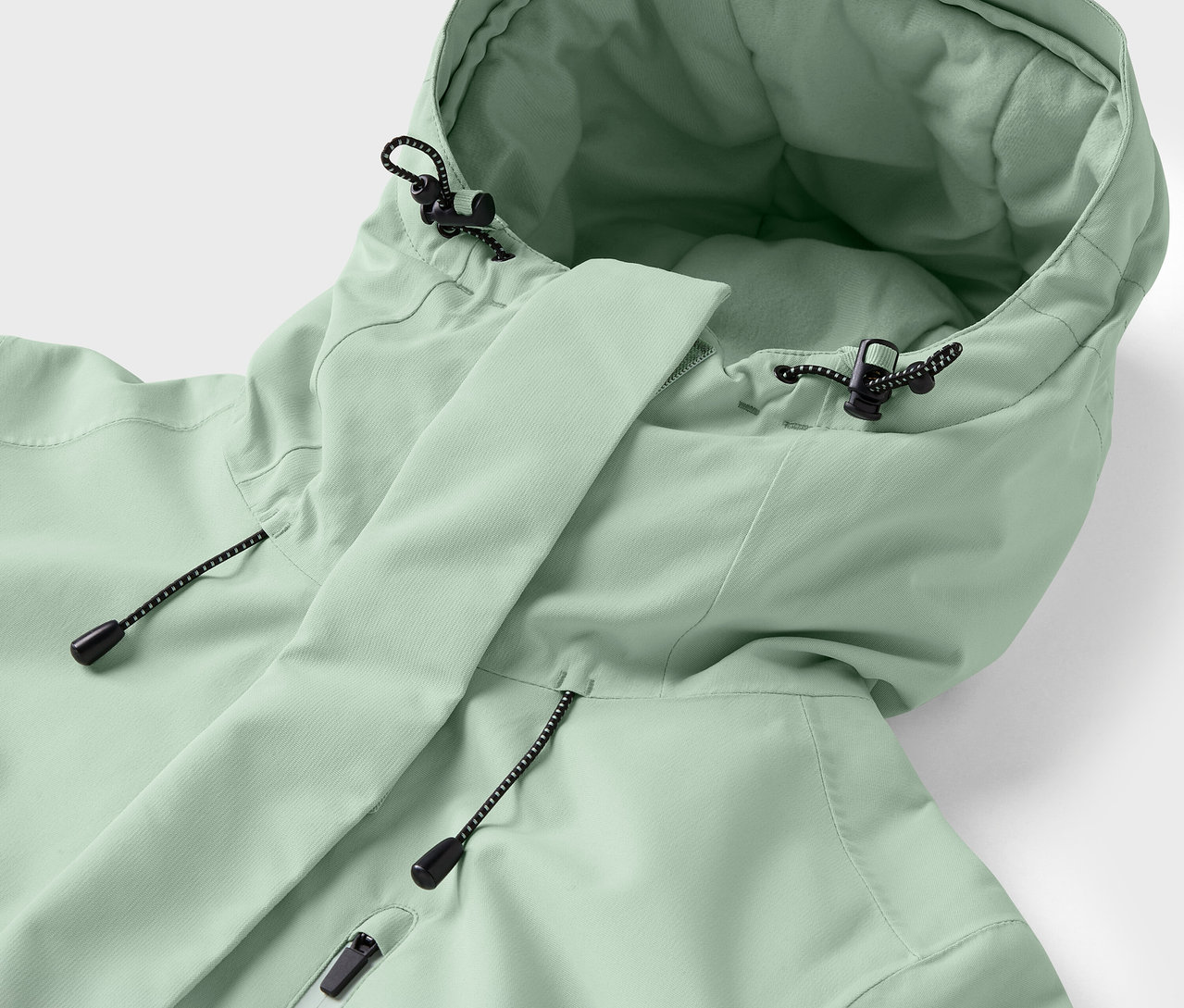 Zbliżenie na jasnozieloną kurtkę z kapturem i sznurkami.