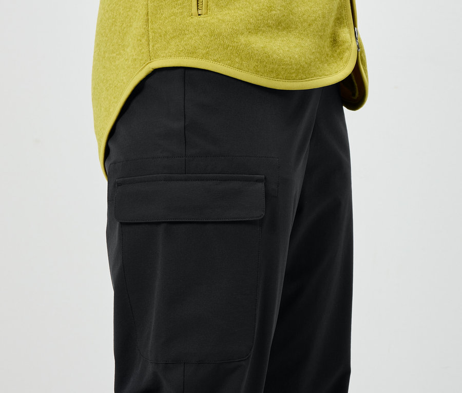 Czarne spodnie z kieszenią i żółta kurtka.