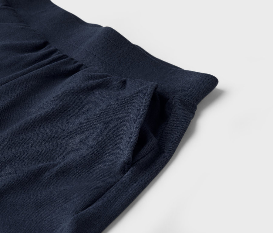Zbliżenie granatowych spodni dresowych z kieszenią na białym tle.