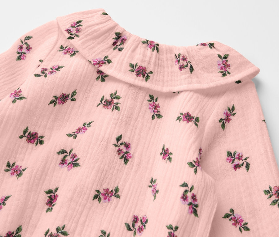 Zbliżenie na muślinowe body z kwiatowym wzorem.