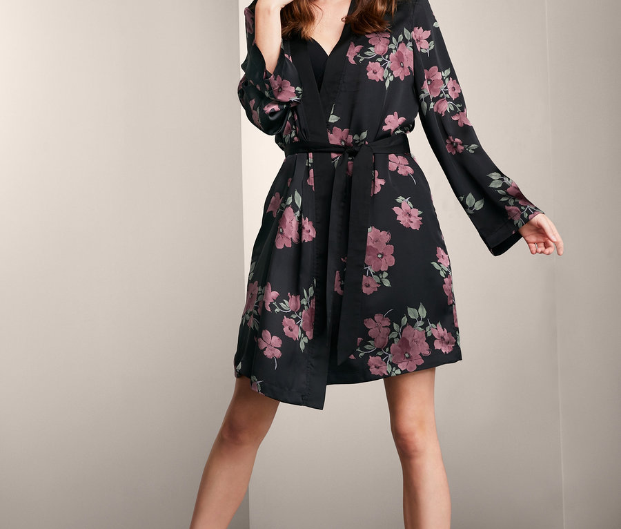 Kobieta pozuje w szlafroku kimono z podszewką z bawełną w kwiatowy wzór.