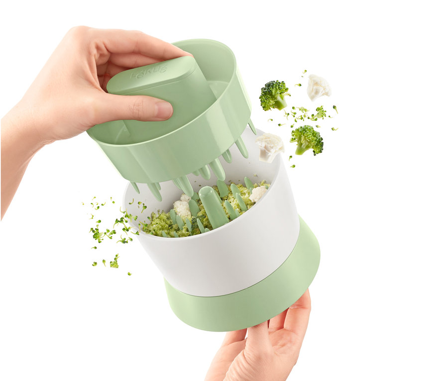 Osoba używa rozdrabniacza do warzyw do krojenia brokułów i kalafiora.