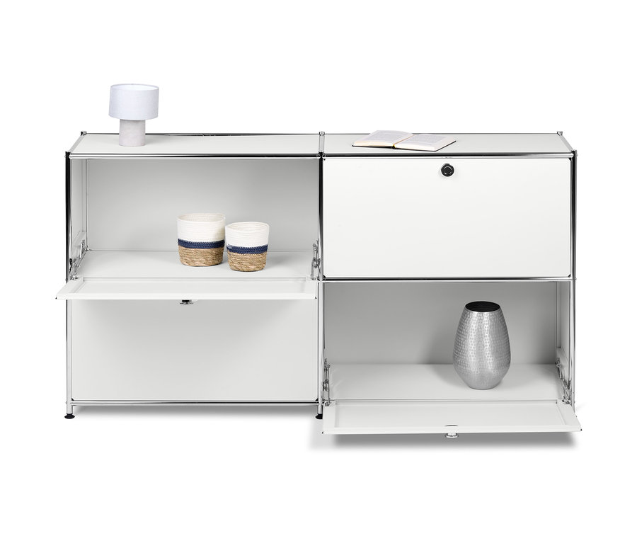 Biała metalowa szafka typu sideboard „CN3” z 4 klapami. Na półkach stoją dwa kosze, lampa i wazon.