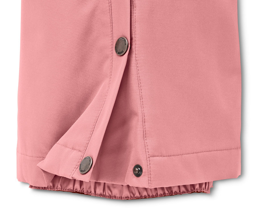 Zbliżenie na różowe spodnie narciarskie i snowboardowe zapinane na zatrzaski.