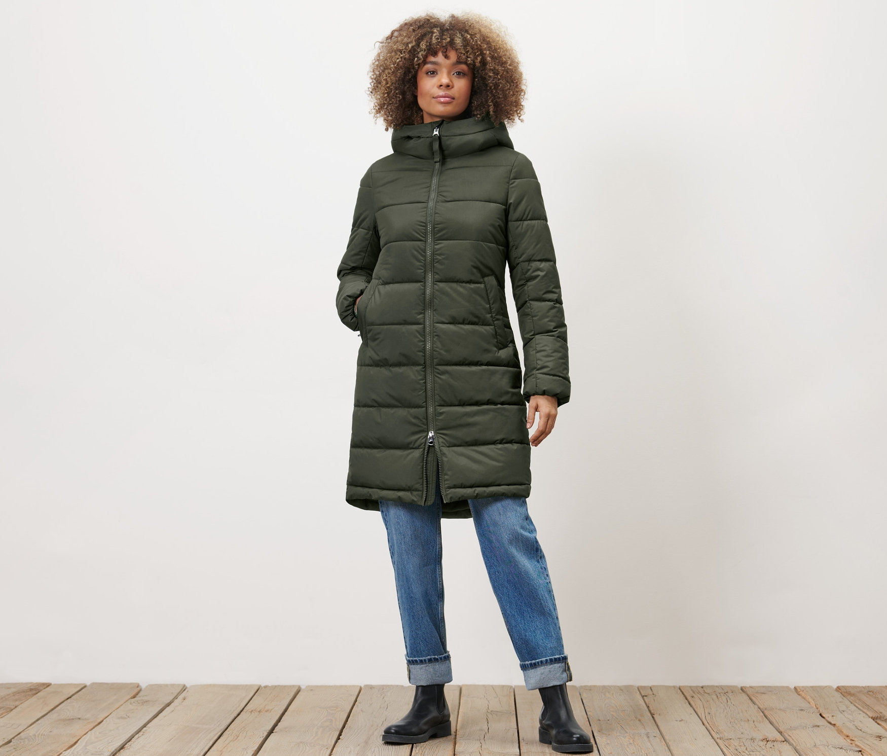 Kobieta pozuje w pikowanym płaszczu khaki.