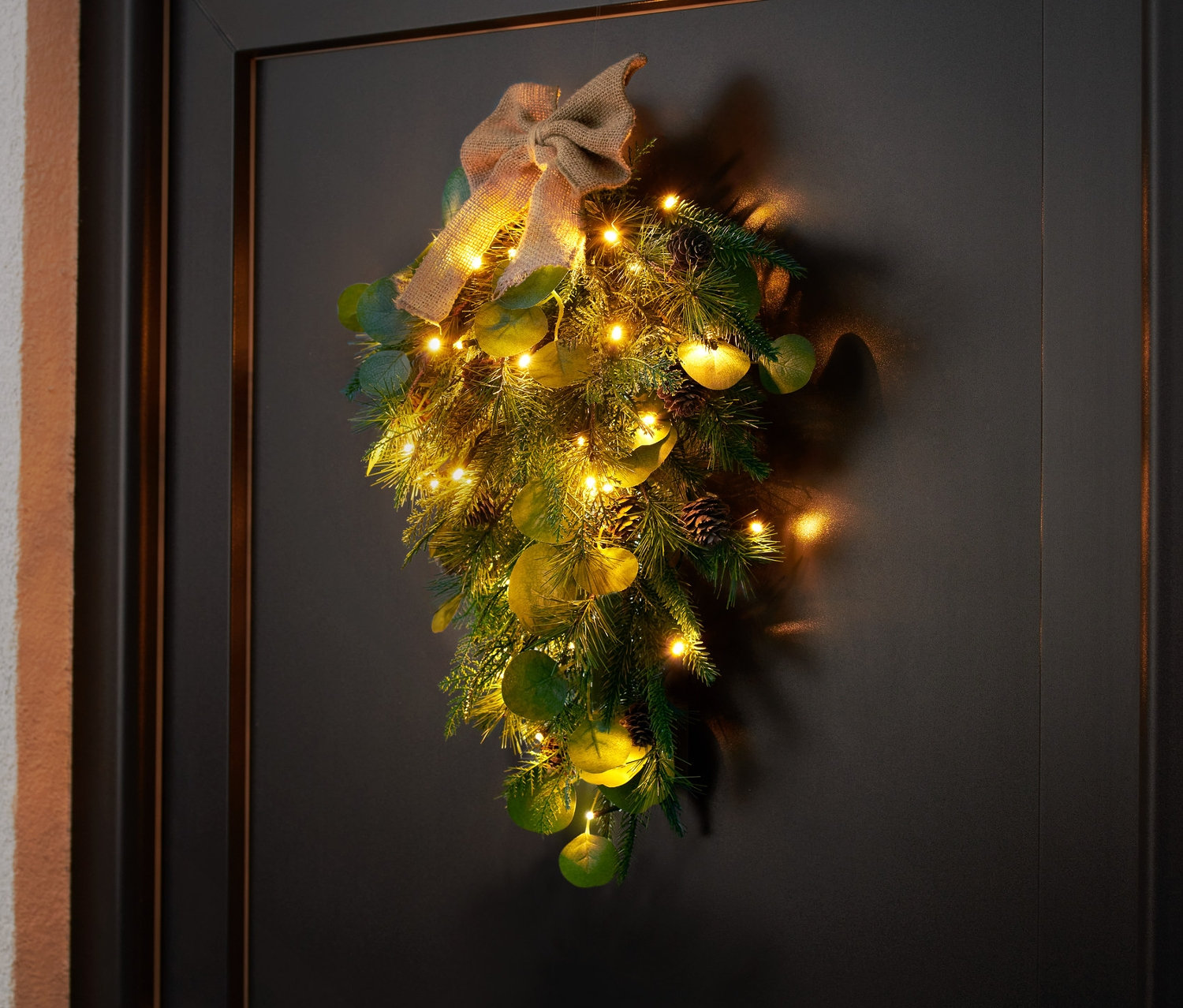 Ozdoba na drzwi LED wisi na czarnych drzwiach.