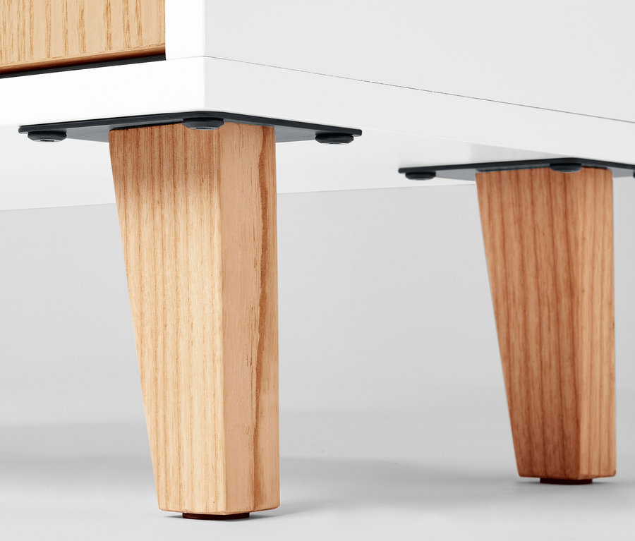 Szczegół szafki łazienkowej z drewnianymi nogami.