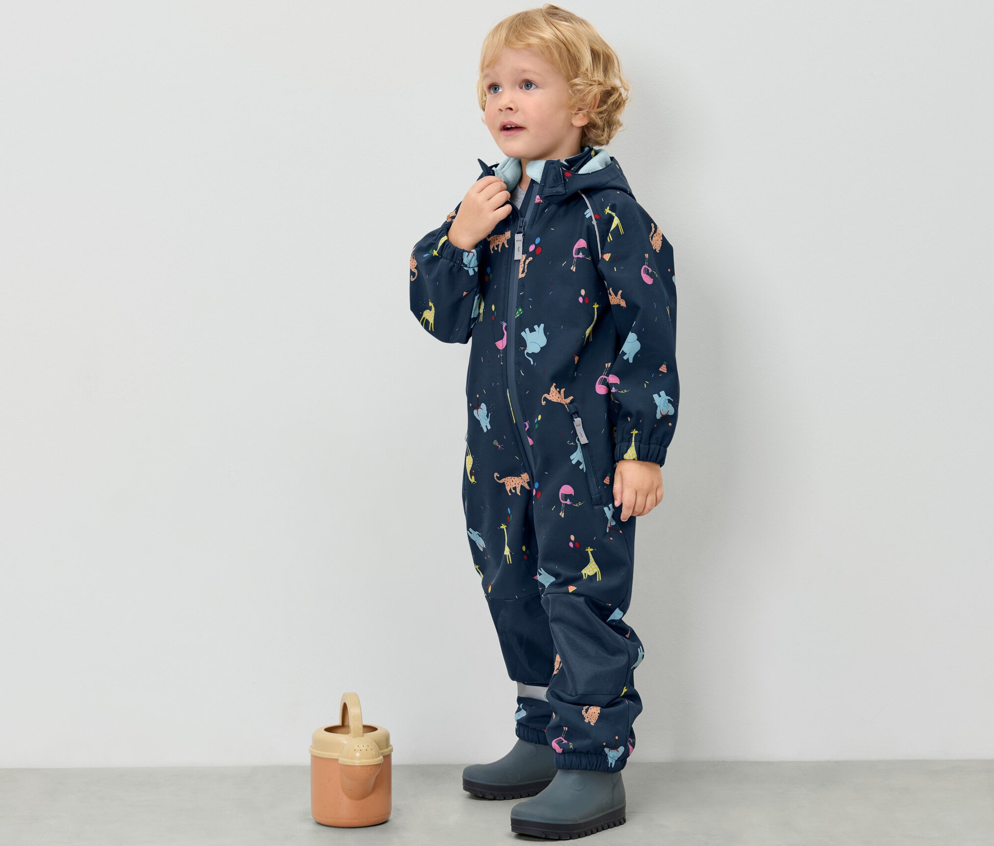 Chłopiec w dziecięcym kombinezonie softshellowym, w zwierzęta.