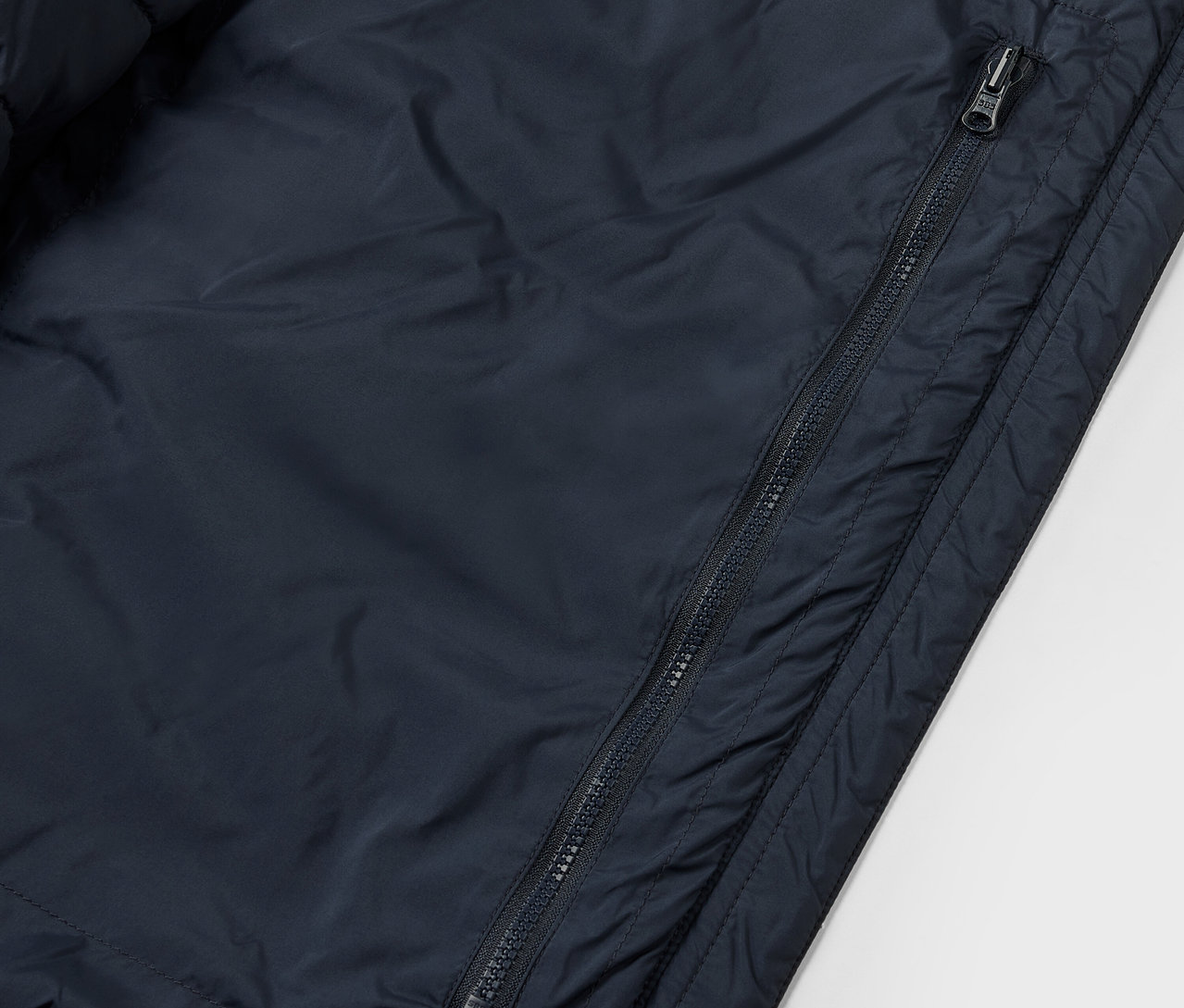 Zbliżenie na kurtkę pikowaną "packable" z widocznym zamkiem błyskawicznym.