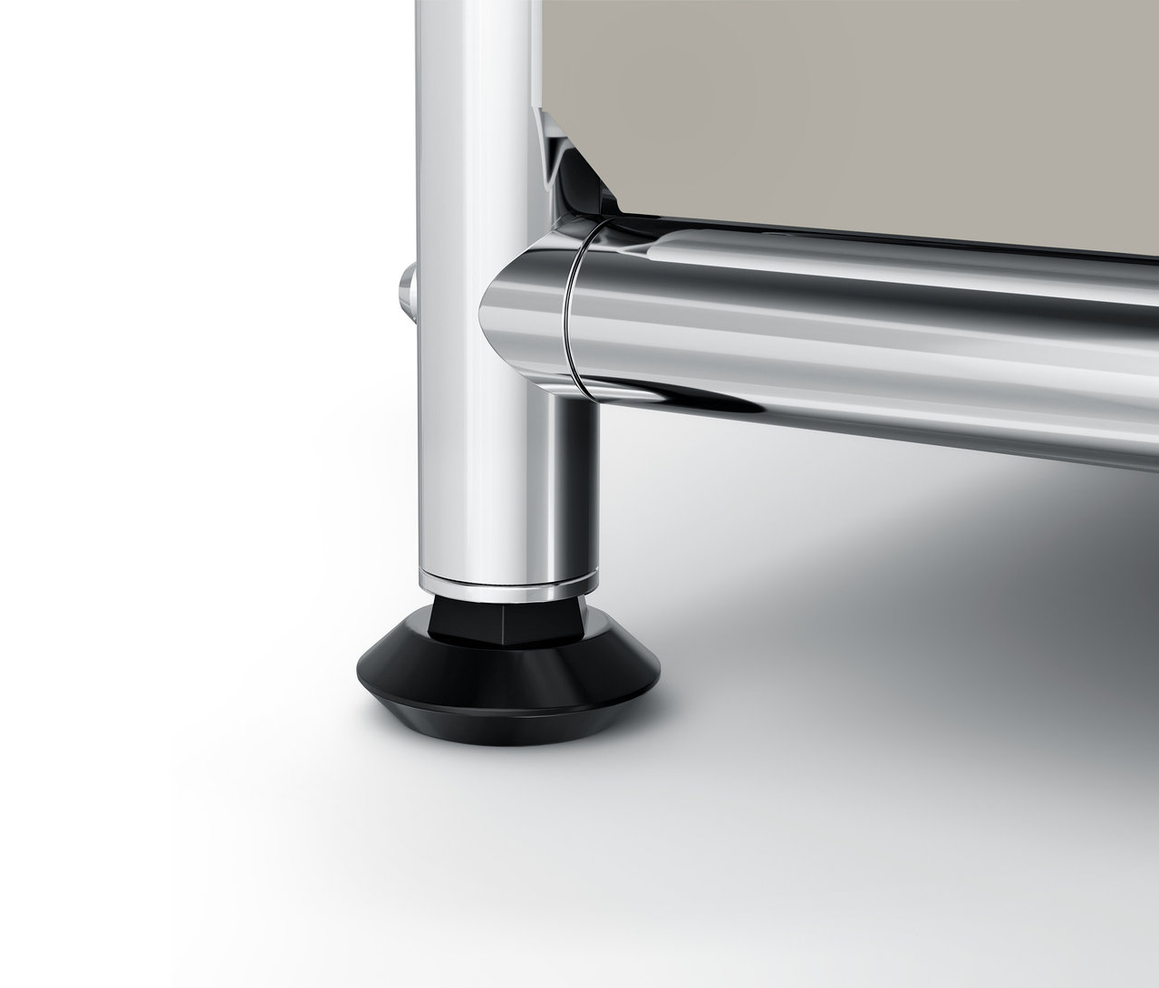 Szczegół chromowanej nogi i czarnej podstawy mebla.