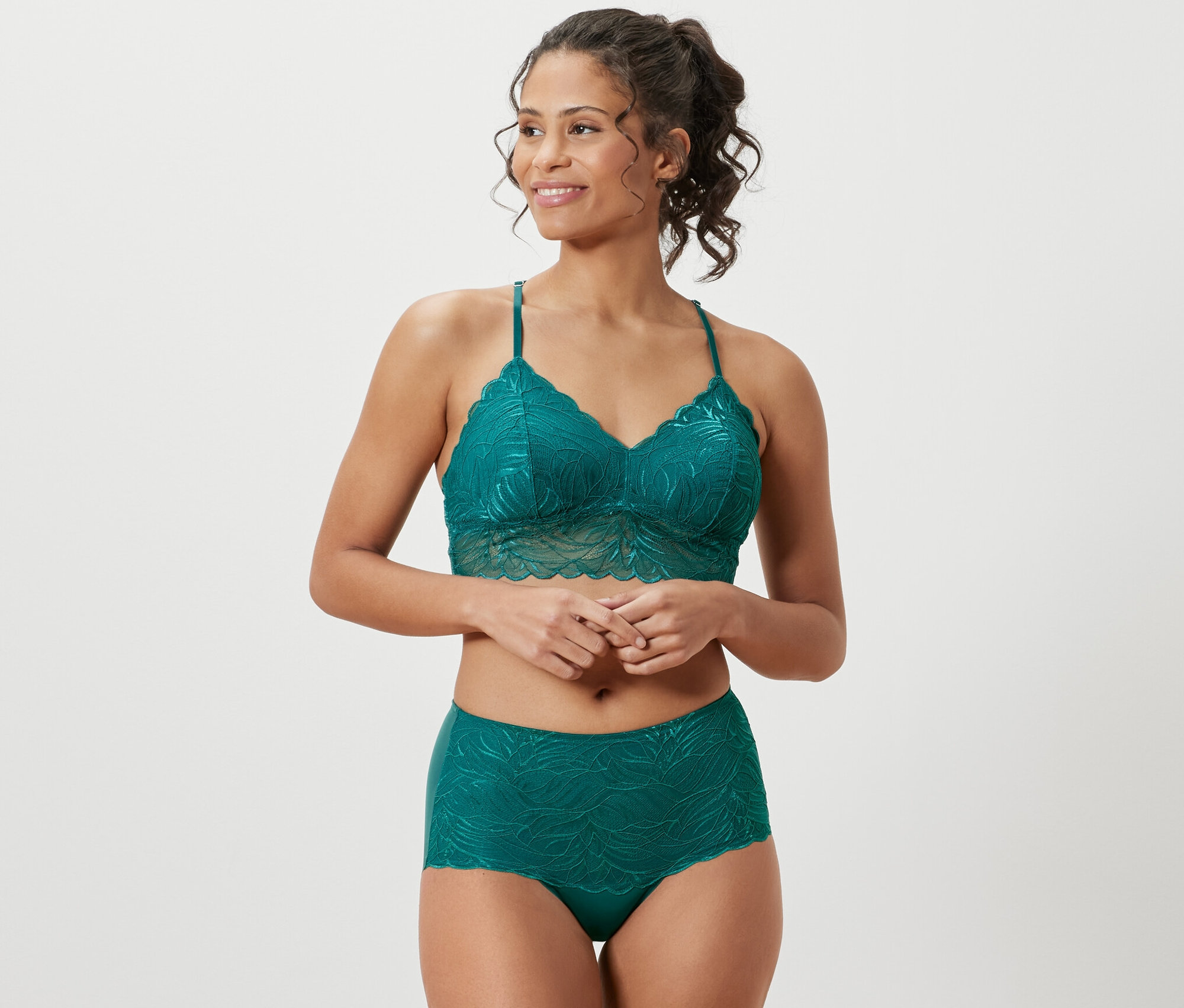 Kobieta ma na sobie koronkowy komplet bielizny w kolorze morskim i lekko modelujące figi z wysokim stanem, morskie.