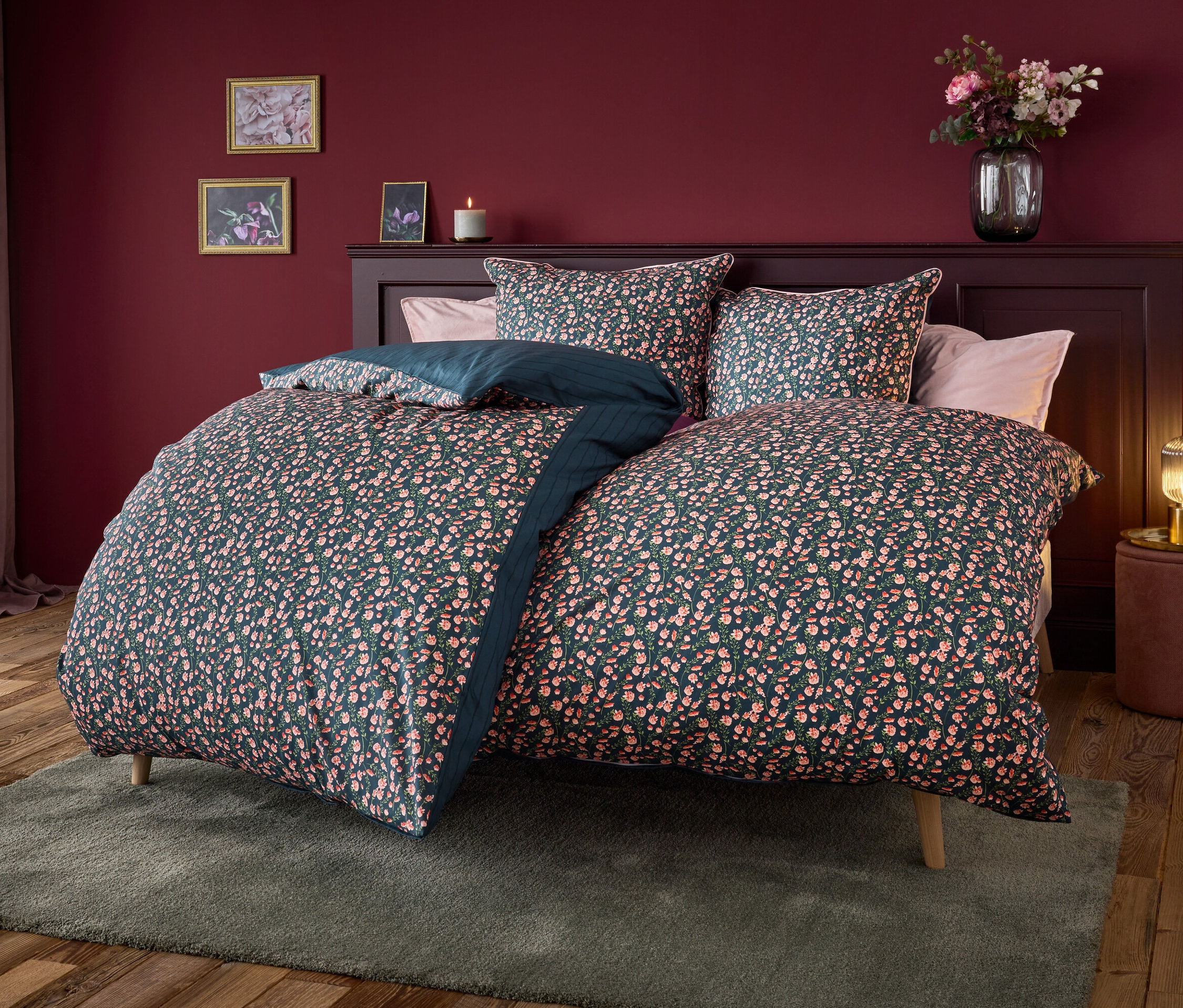 Łóżko z granatową pościelą w kwiatowy wzór.