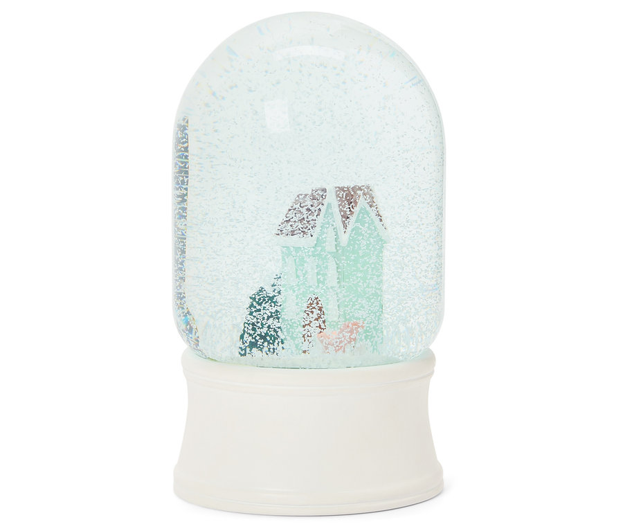 Kula śnieżna z domem w środku, na białej podstawie.