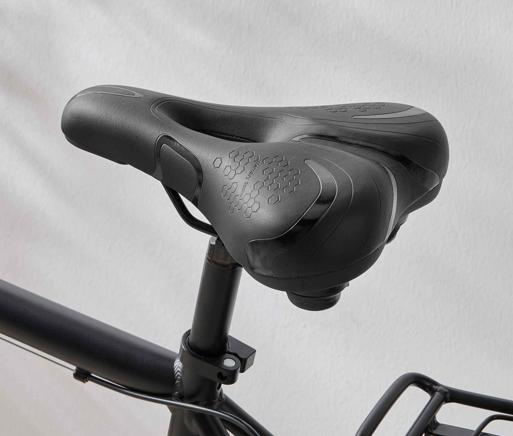Zbliżenie czarnego siodełka rowerowego z wzorem sześciokątów na siedzisku.