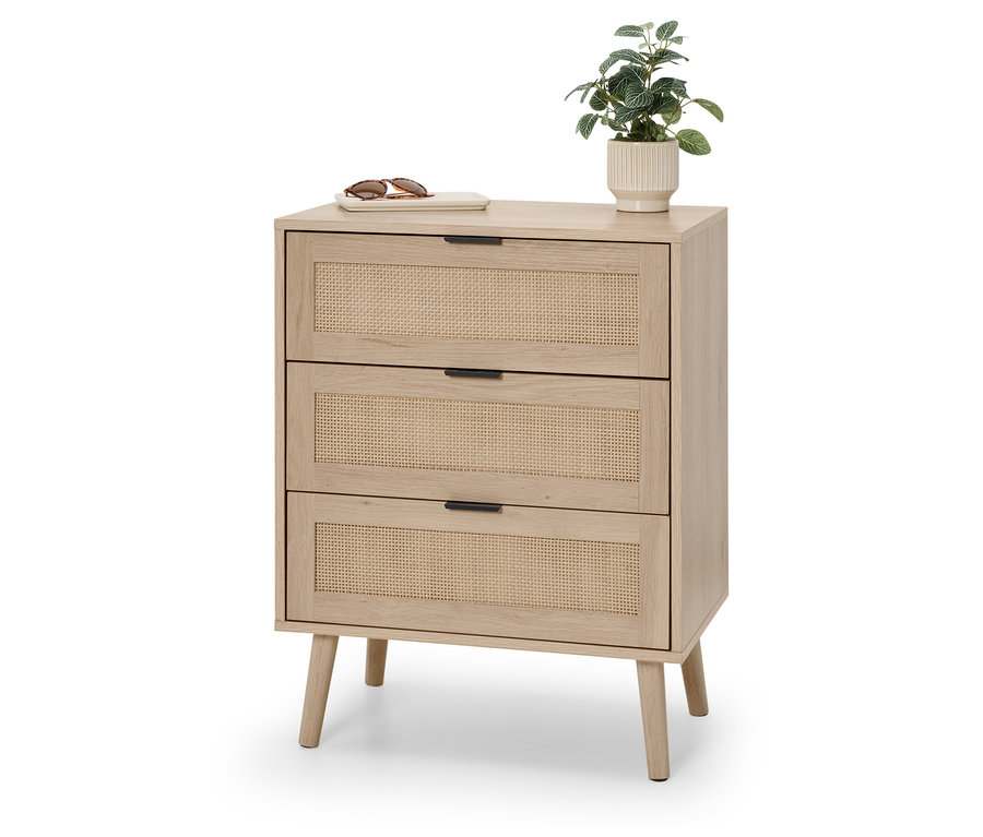 Komoda z trzema rattanowymi szufladami, na której leżą okulary przeciwsłoneczne i mała roślina.