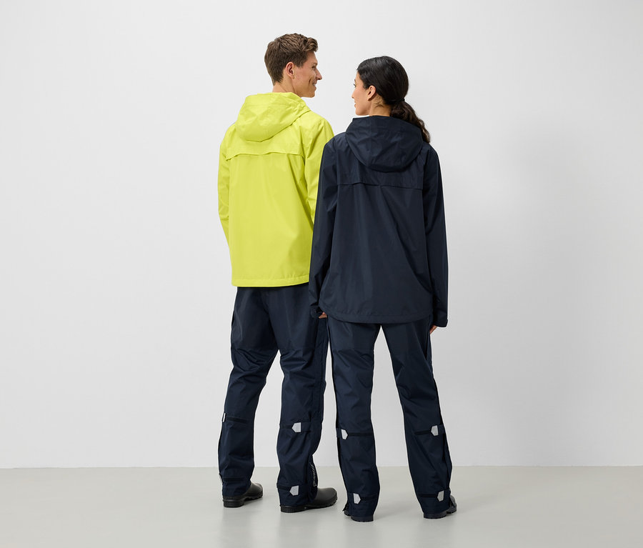 Mężczyzna i kobieta stoją do siebie plecami, ubrani w kurtki i spodnie przeciwdeszczowe.