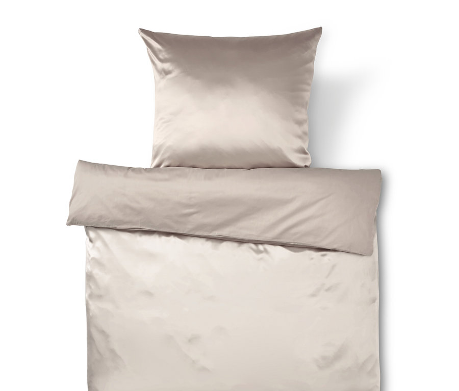 Beżowa satynowa pościel z poduszką i kołdrą.