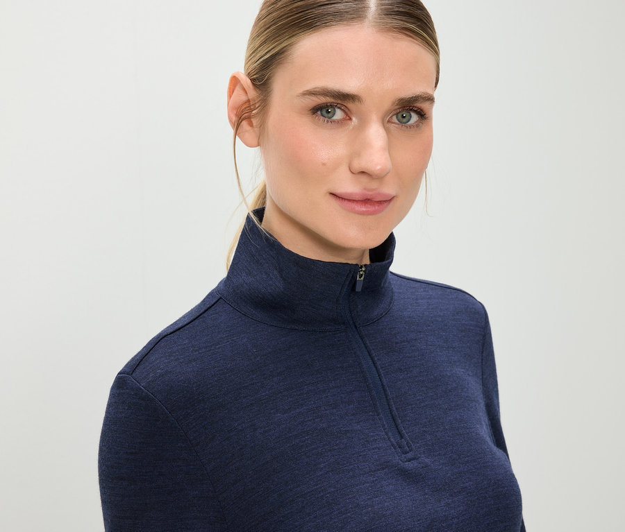 Portret blondynki w niebieskiej bluzie z zamkiem błyskawicznym.