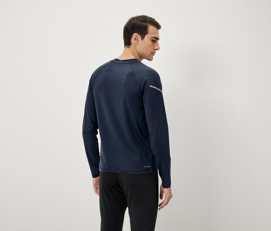 Mężczyzna z tyłu w granatowej koszulce z długim rękawem i czarnych spodniach.