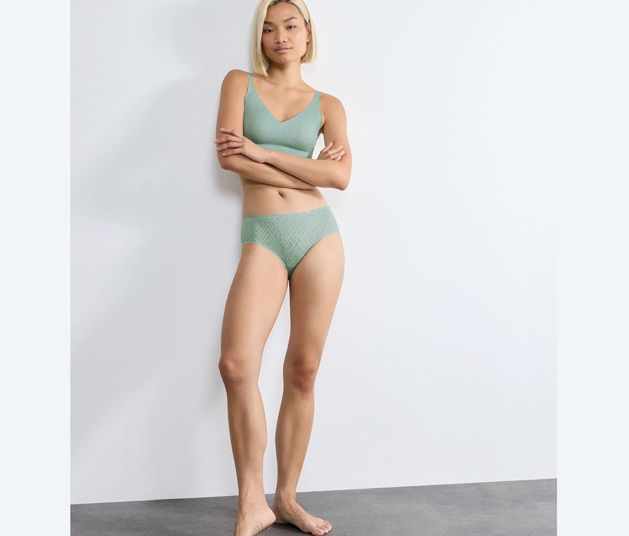 Kobieta pozuje w figach typu hipster sloggi ZERO Feel Bliss, misty turquoise.