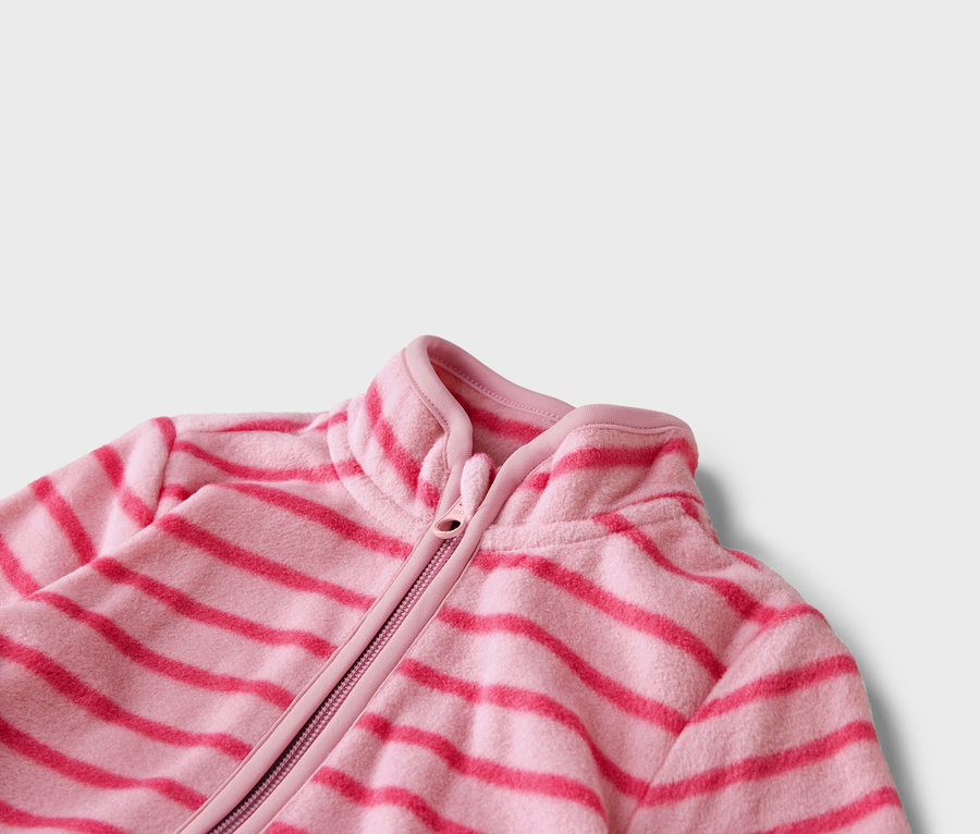Zbliżenie różowej kurtki polarowej w poziome, ciemnoróżowe paski z zamkiem błyskawicznym.