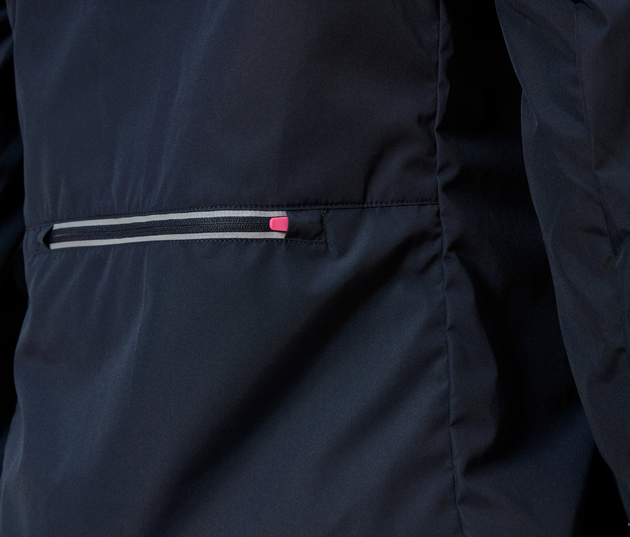 Zdjęcie z bliska granatowej kurtki z kieszenią na zamek błyskawiczny, którego suwak ma różowy akcent.