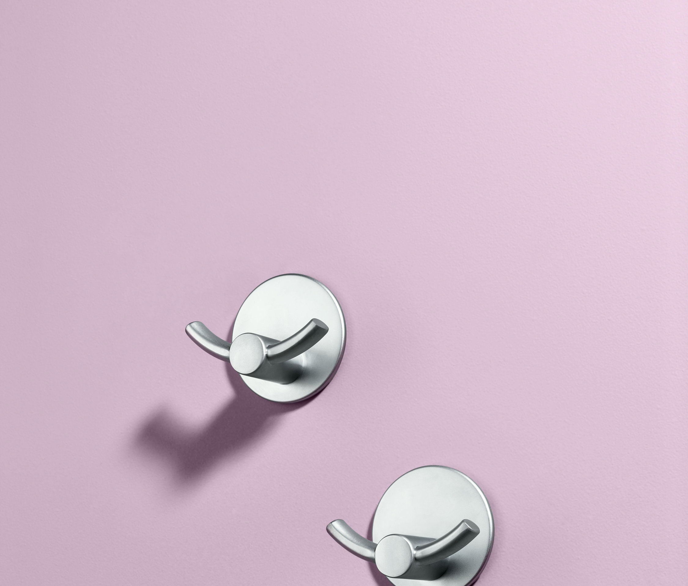 Dwa samoprzylepne podwójne haczyki na fioletowej ścianie.