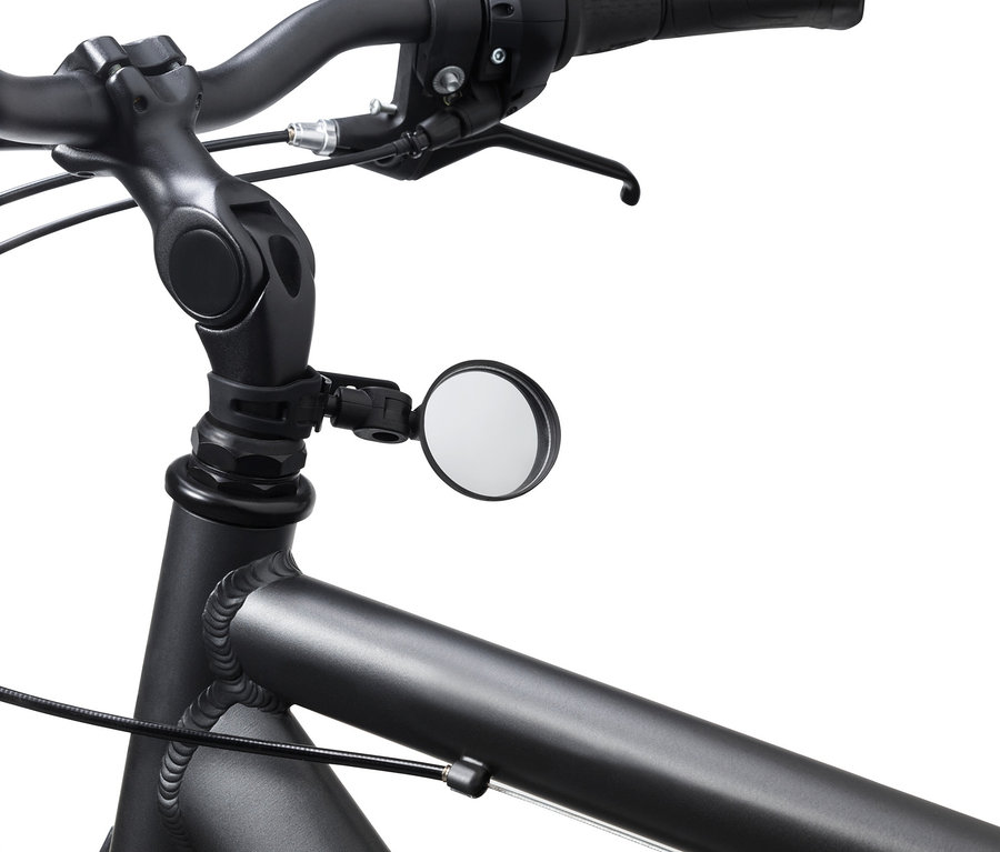 Zbliżenie roweru z czarną kierownicą i małym lusterkiem rowerowym.