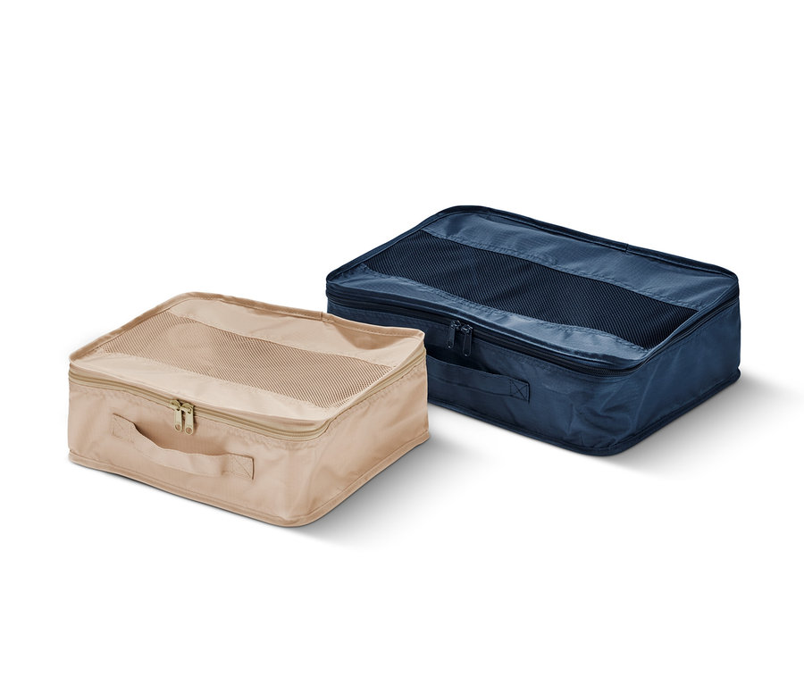 Dwa organizery podróżne, jeden beżowy i jeden granatowy, leżą na białym tle.