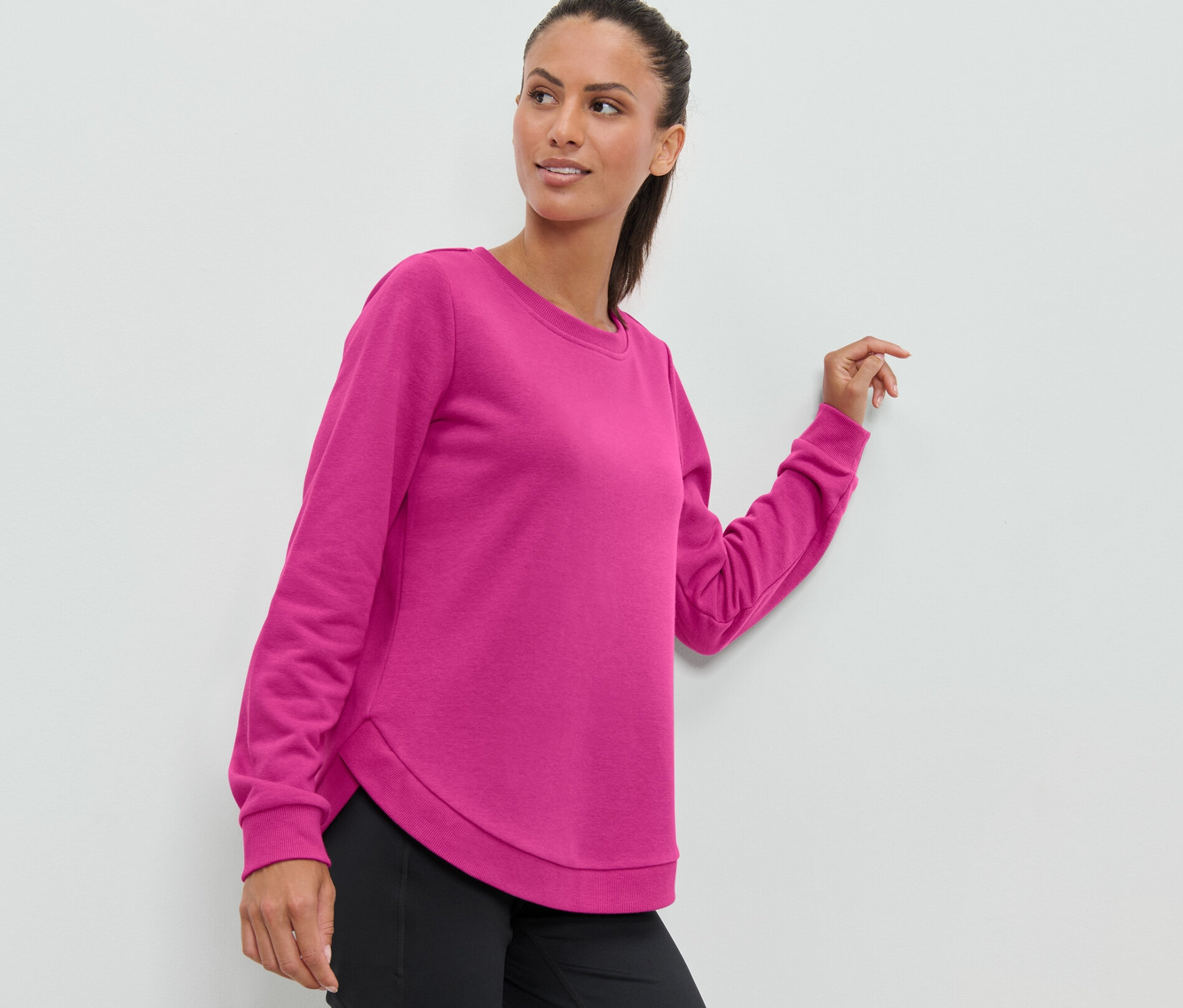 Kobieta ma na sobie różową bluzę sportową.