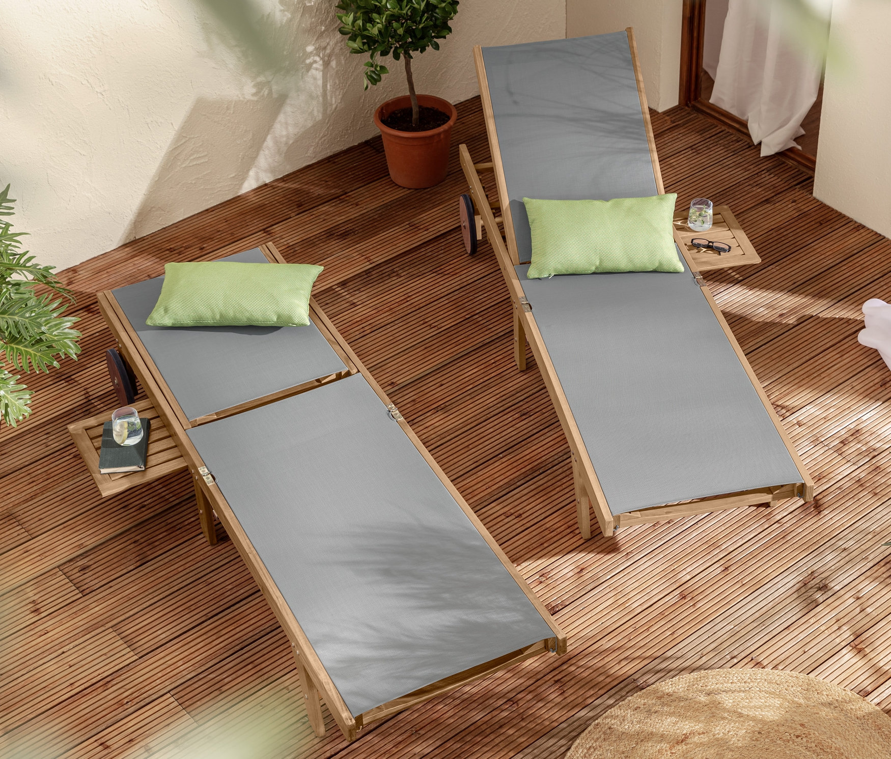 Dwa leżaki z wysuwanym stolikiem »Lenja« i 2 poduszki outdoorowe na drewnianym tarasie.