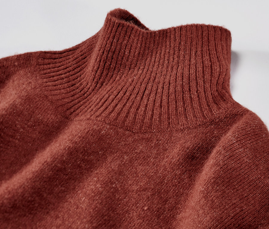 Zbliżenie na brązową dzianinową sukienkę z wełną i golfem.