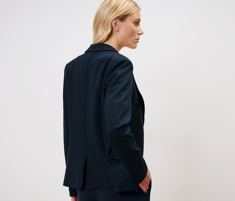 Blondynka w żakiecie z dżerseju.