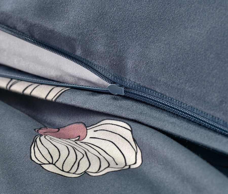 Zbliżenie na zamek błyskawiczny granatowej pościeli z mikrowłókna z kwiatowym wzorem.