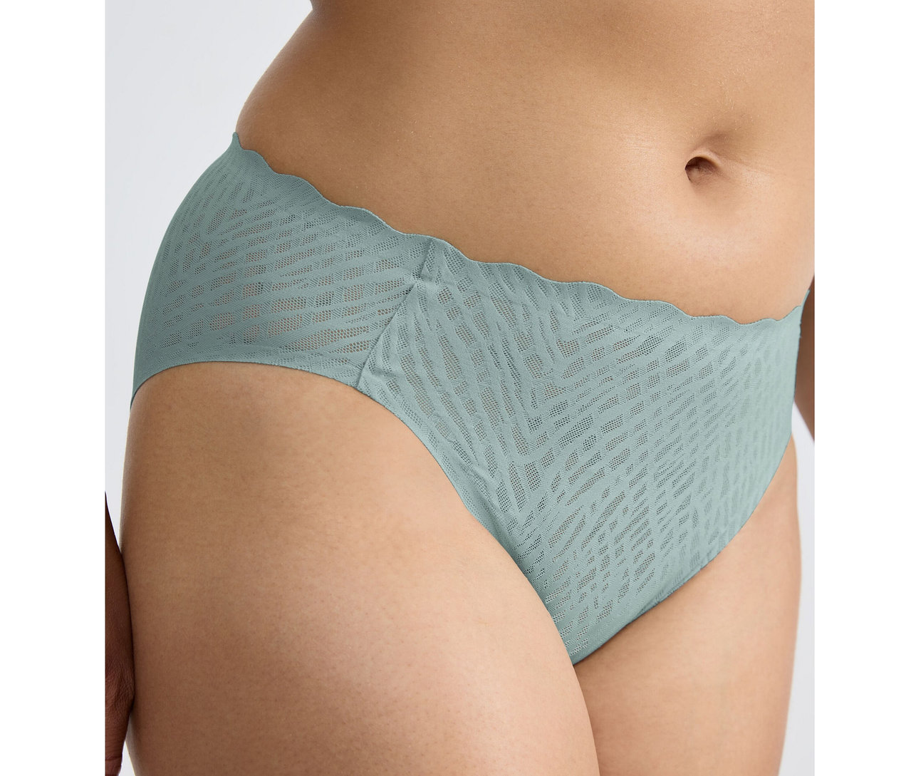 Biodro osoby w figach high leg sloggi ZERO Feel Bliss w kolorze misty turquoise, z falistym brzegiem w pasie i subtelnym wzorem.