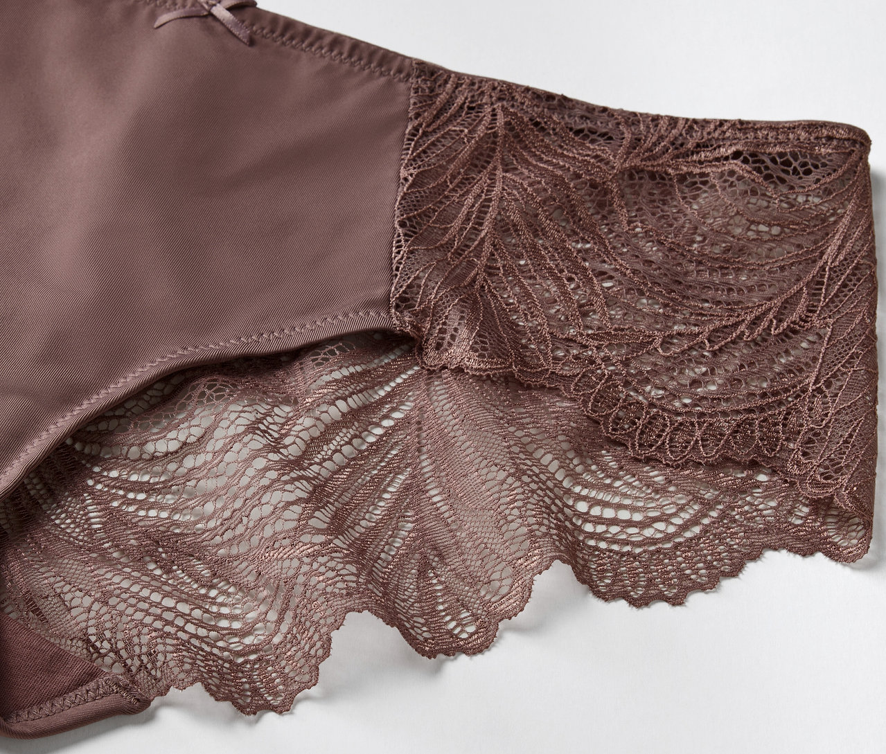 Szczegół brązowych majtek z kwiatową koronką.