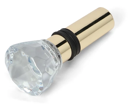 Korek do butelki ze szklaną ozdobą w kształcie diamentu i złotą metalową podstawą.