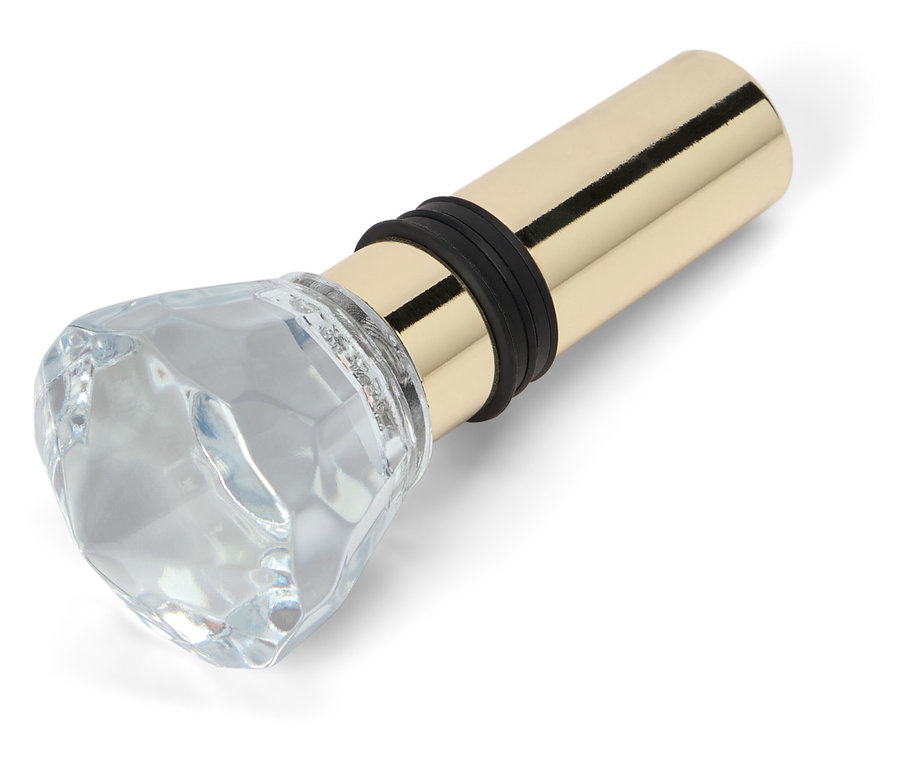 Korek do butelki ze szklaną ozdobą w kształcie diamentu i złotą metalową podstawą.
