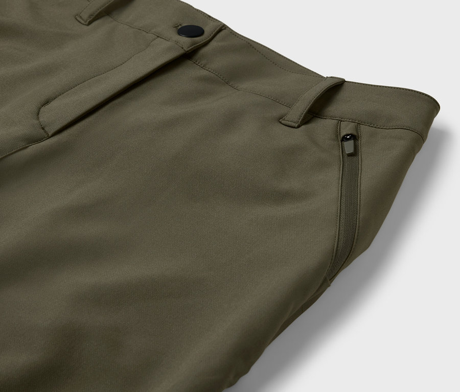 Szczegół oliwkowozielonych spodni z kieszenią na zamek.