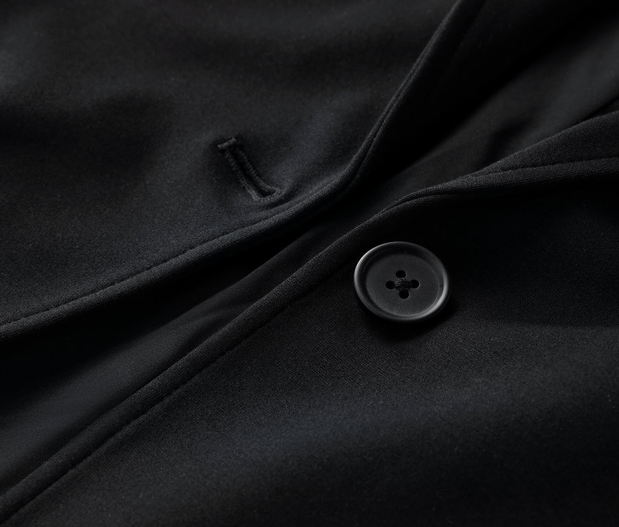 Zbliżenie na czarny żakiet z dżerseju z guzikiem.
