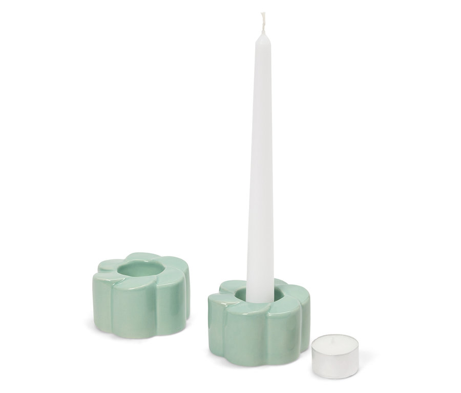 Dwa jasnozielone świeczniki w kształcie kwiatów, w jednym biała świeca, obok świeczka typu tealight.