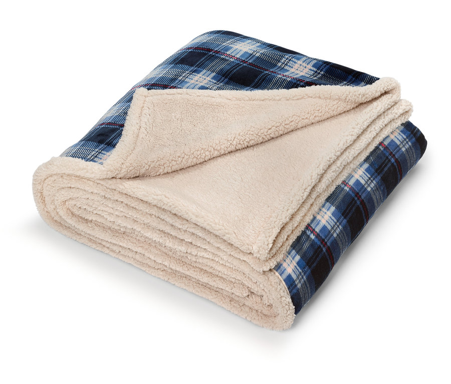 Złożony koc w niebieską kratę z kremową podszewką sherpa.