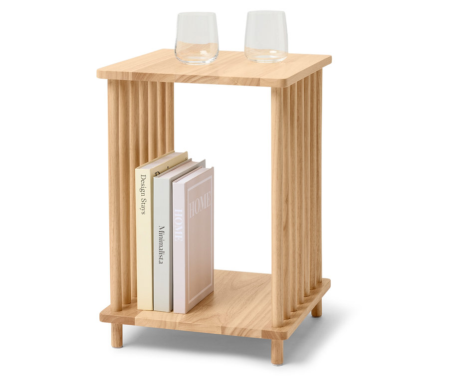 Dwa szklane kieliszki stoją na drewnianym stoliku. Pod nimi leżą trzy książki.